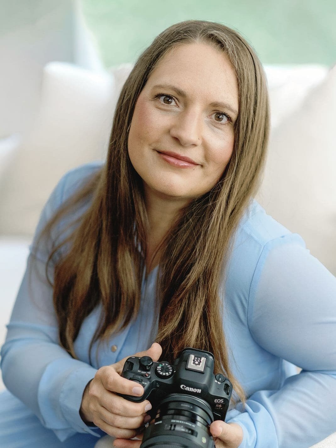 Joyful Charlotte NC professional photographer, Karen Lee Mayes, holding camera and smiling