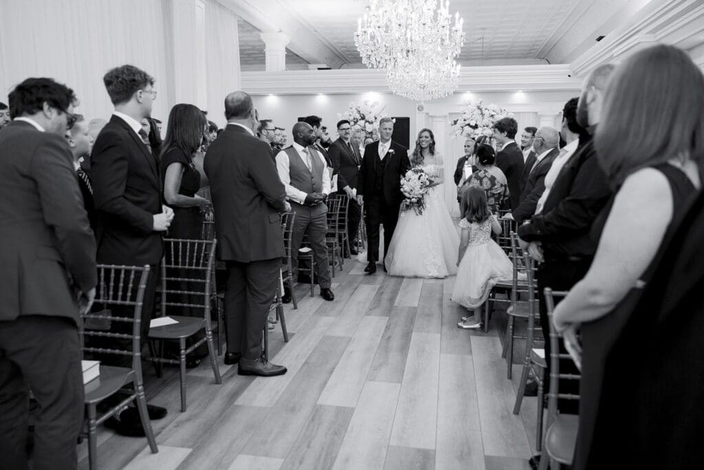 Father walking his daughter down the aisle in a ballroom